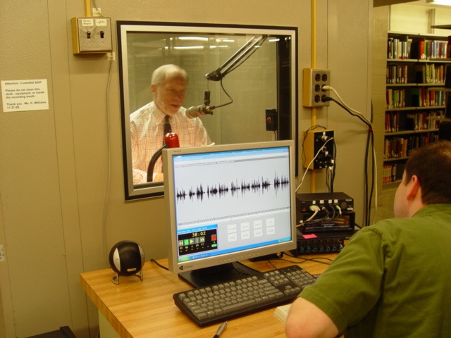 Charles Bierbauer reading in the sound booth for Talking Book Servbices
