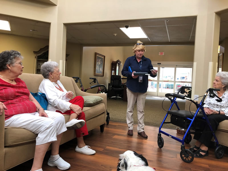 Woman displaying Talking Book Services equipment at a seniors' center